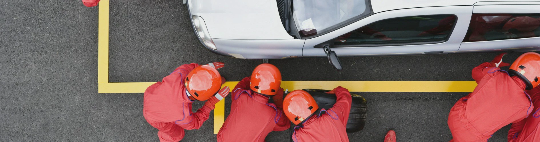 Ekipa wulkanizacyjna wymieniająca oponę w samochodzie